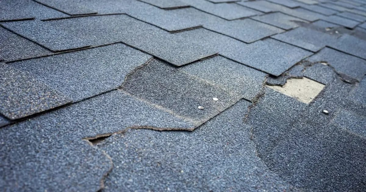 Missing and broken shingles on a Maryland roof due to storm damage